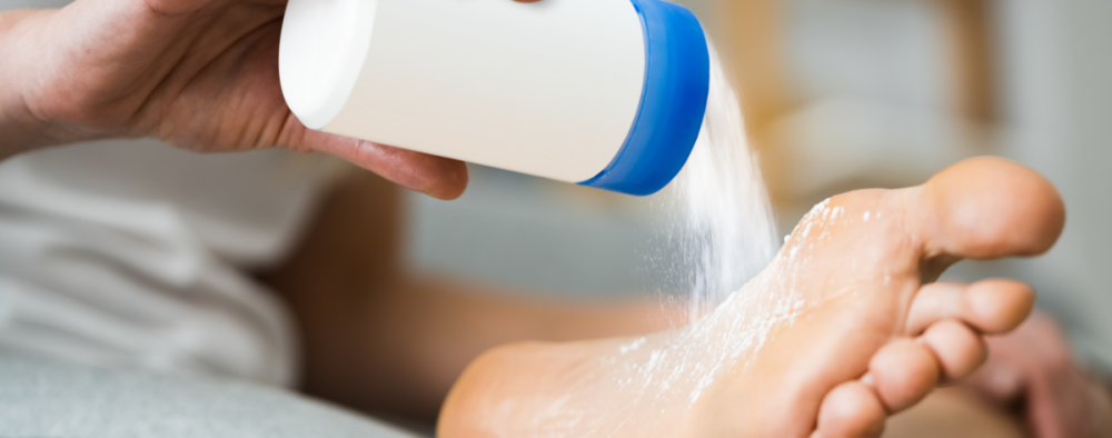 Henkilö levittää jalkapuuteria jalkapohjiinsa