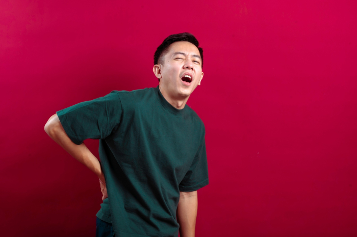 Välilevyn pullistuma, aasialainen mies kärsimässä pahoista selkäkivuista