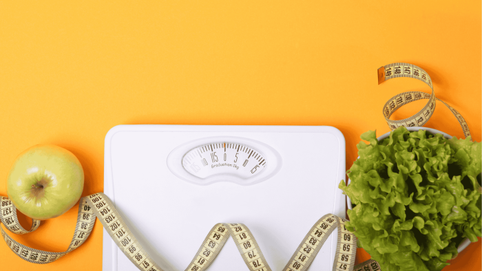 Puntari, salaattia ja mittanauha oranssilla taustalla. 