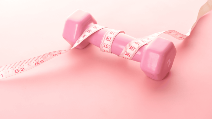 Käsipaino pinkilla taustalla