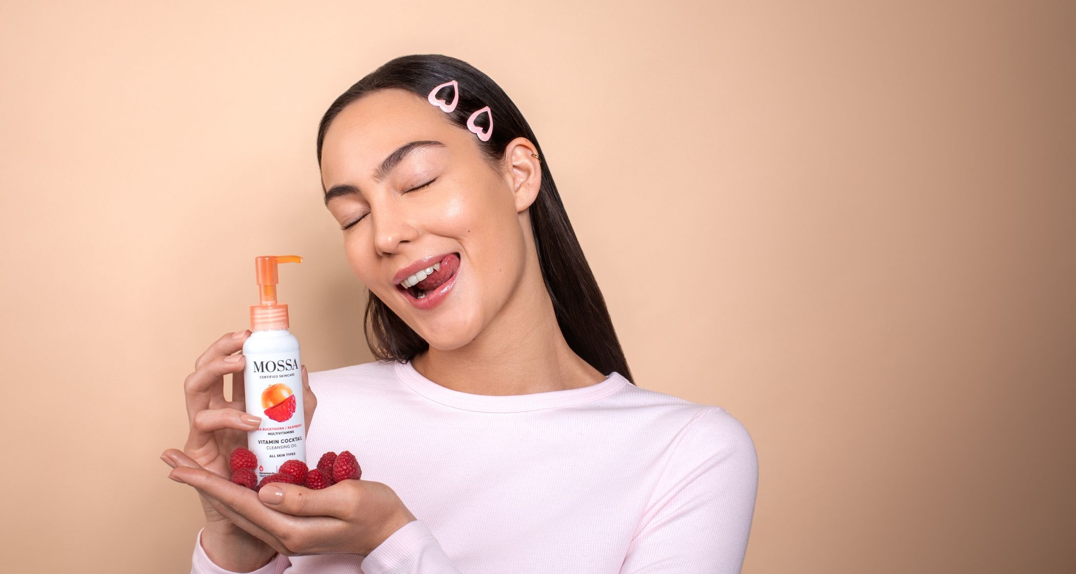 Nuori nainen pitelee Mossa Vitamin Cocktail ihonhoitotuotetta