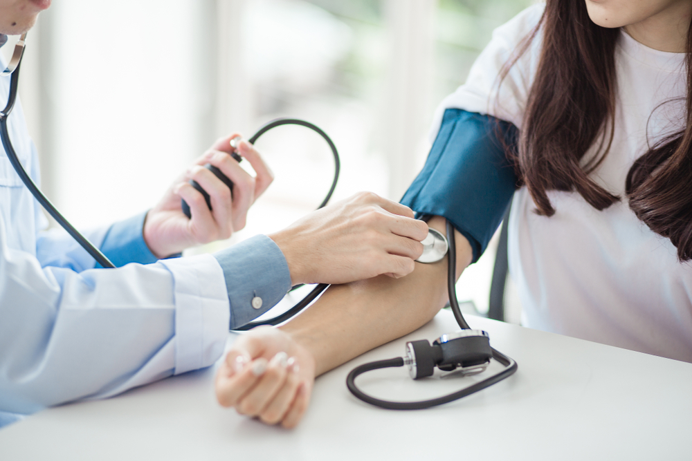 Verenpaine ja ruokavalio kulkevat käsi kädessä. Kuvassa lääkäri mittaamassa naisen verenpainetta.