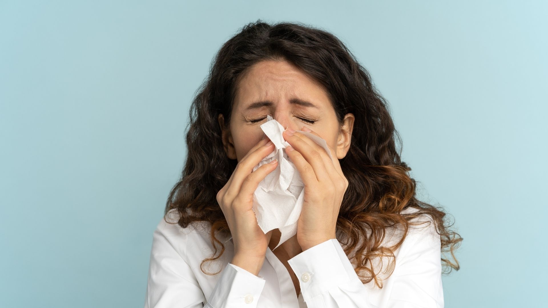 Nainen niistämässä nenää. Kuvituskuva kuvaamassa allergiaoireita.