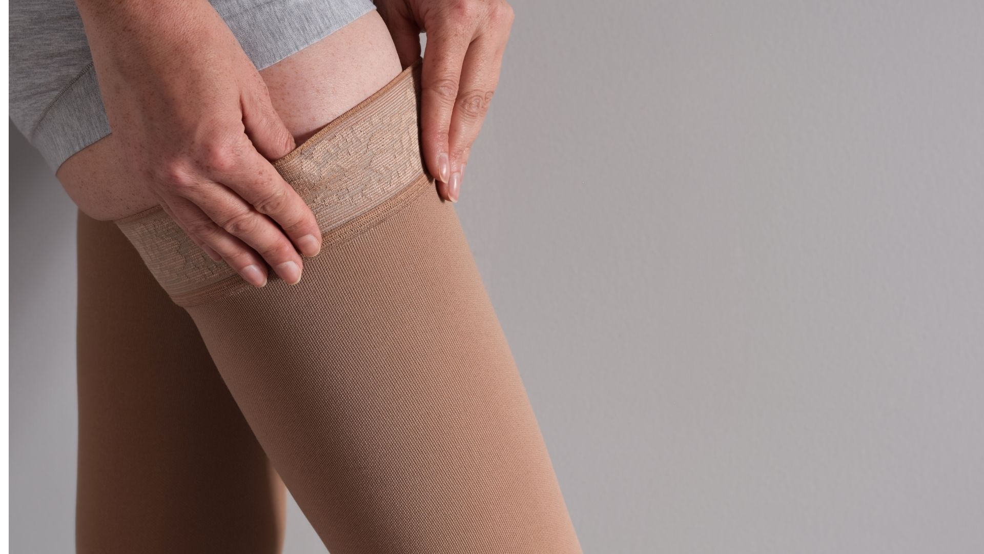 Nainen pukemassa kompressiosukkaa nesteenpoistoon.