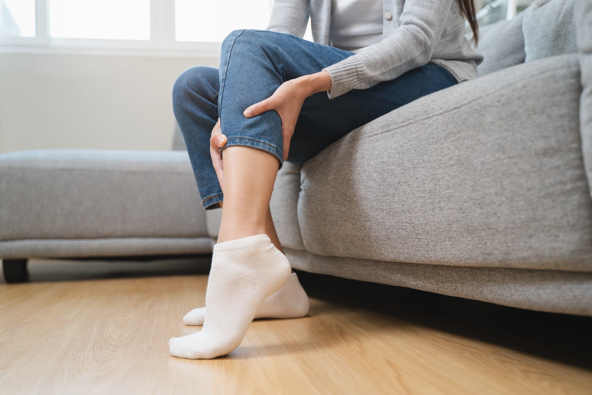 Nainen pitelee jalkaa