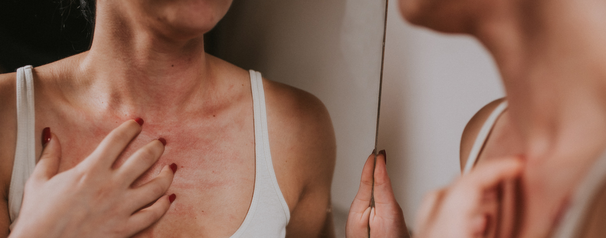 Nainen tutkii kaulan iho peilistä